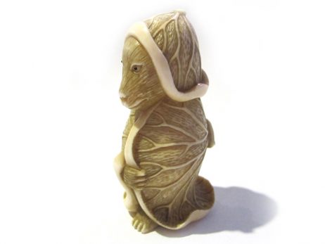 Tanuki du Japon dans une feuille de lotus, sujet de netsuke en ivoire