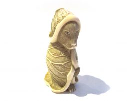 Tanuki ou blaireau dans une feuille de lotus, sujet de netsuke en ivoire